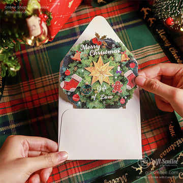 Close-up of a 3D pop-up Christmas card with a festive wreath design and Merry Christmas text