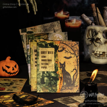 Close-up of vintage Halloween scrapbook paper featuring a black cat, pumpkins, and bats