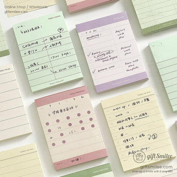 Pastel-colored daily planner pads with handwritten notes and grid designs