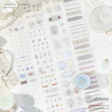 Flat lay of vintage floral washi tape and stickers on lace fabric with pearls