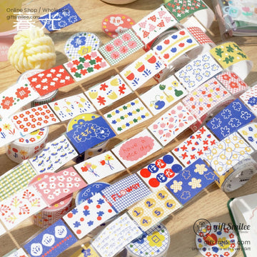 A colorful assortment of floral and patterned washi tape rolls displayed on a wooden surface