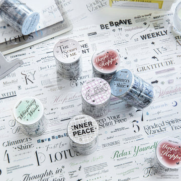 Vintage washi tape rolls with inspirational quotes displayed on a scrapbook page