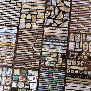Close-up of retro scrapbooking stickers and ephemera paper strips on a wooden surface
