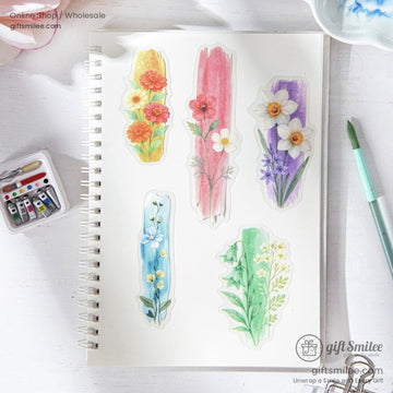 A notebook decorated with colorful ink-dyed floral stickers, including daisies and poppies