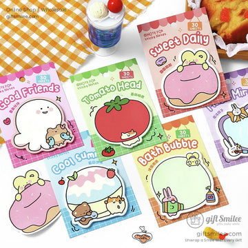Image of a variety of kawaii sticky notes featuring adorable animal and food designs displayed on a table with vibrant props