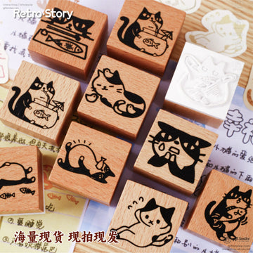 A collection of wooden cat rubber stamps with playful, retro feline designs arranged on a wooden surface
