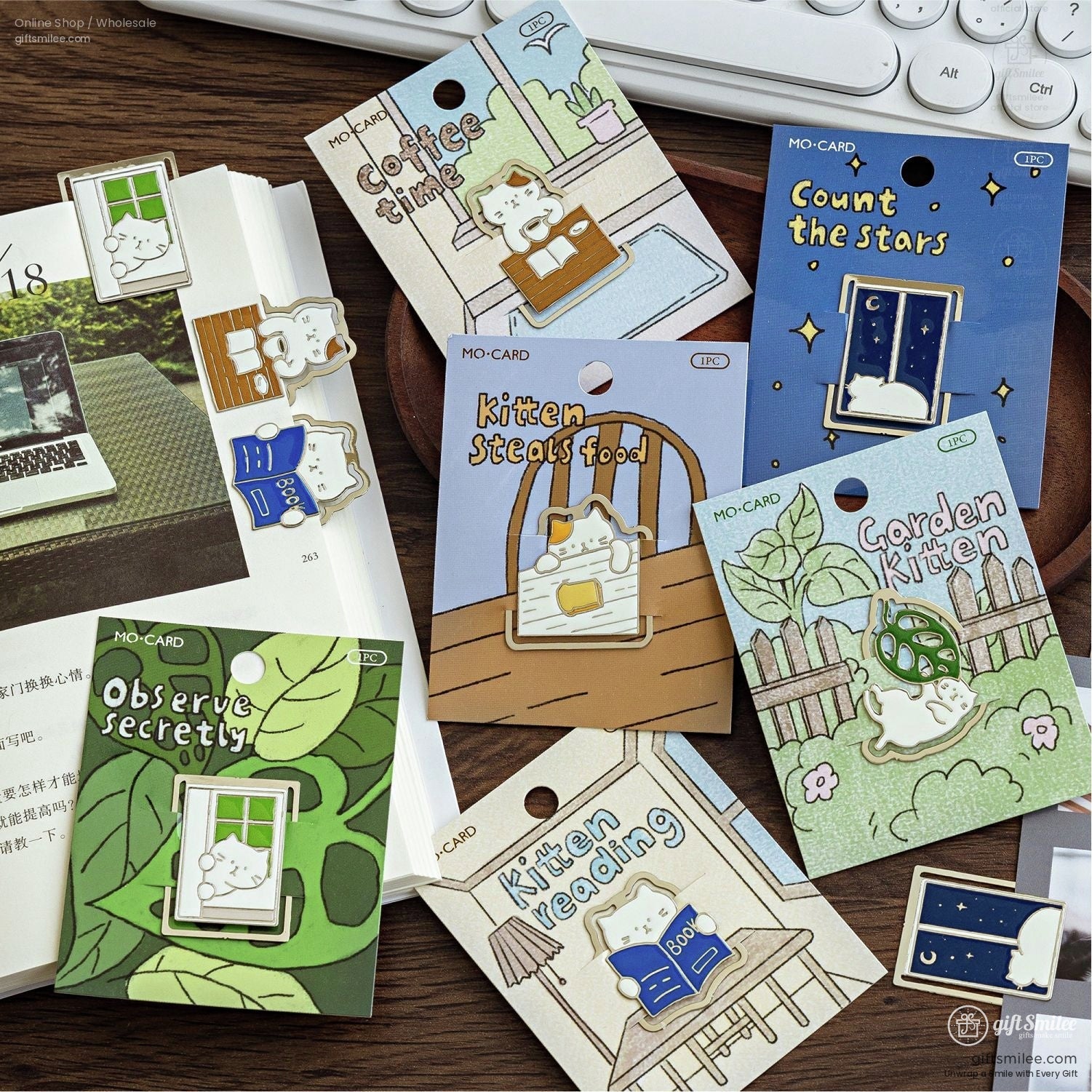 Packaged cat-themed enamel bookmarks with creative designs like "Kitten Reading" and "Count the Stars."