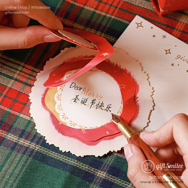 Writing a personal message inside a pop-up Christmas card with a red Santa hat design