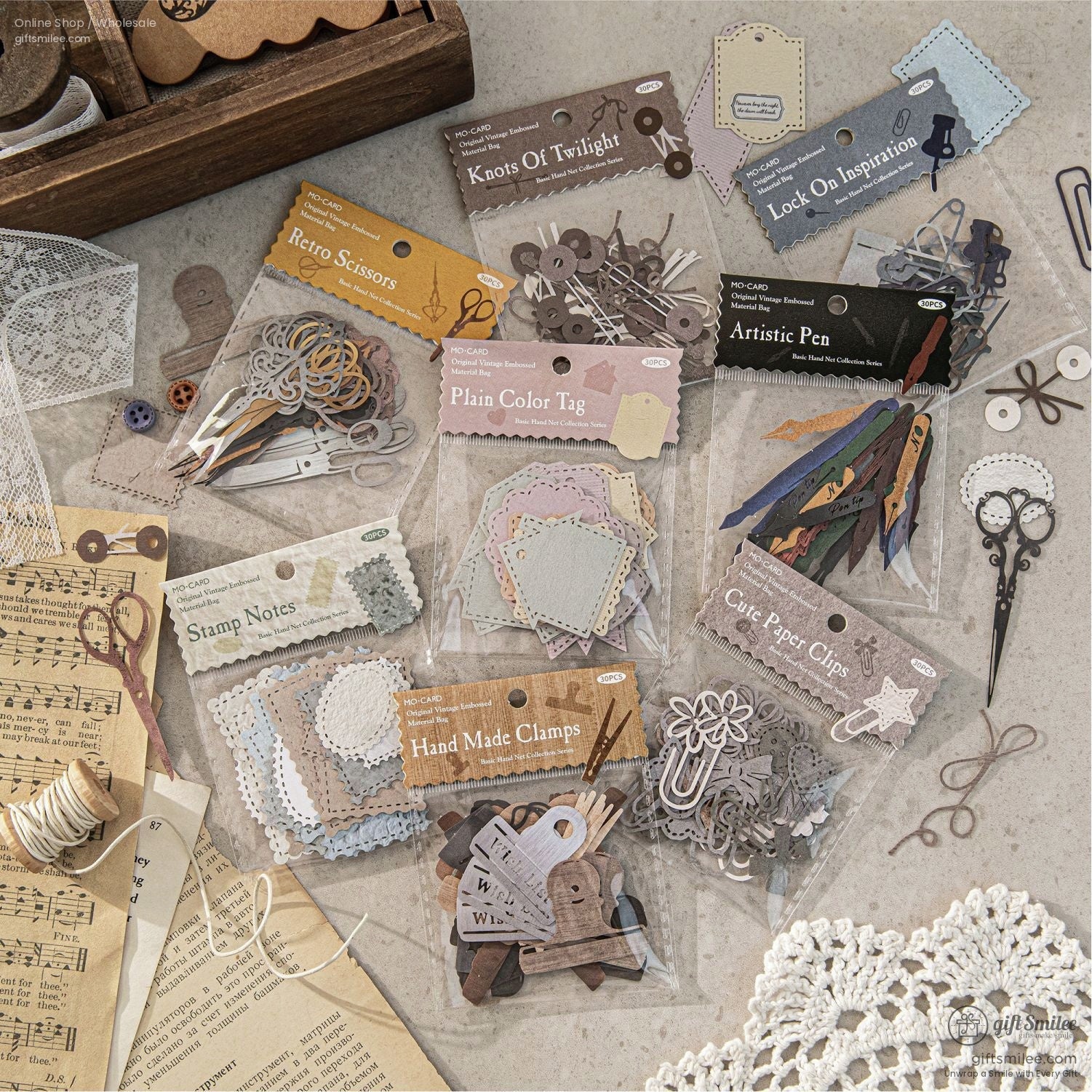 A collection of retro stationery supplies, including paper tags, artistic pens, and decorative clips, perfect for scrapbooking