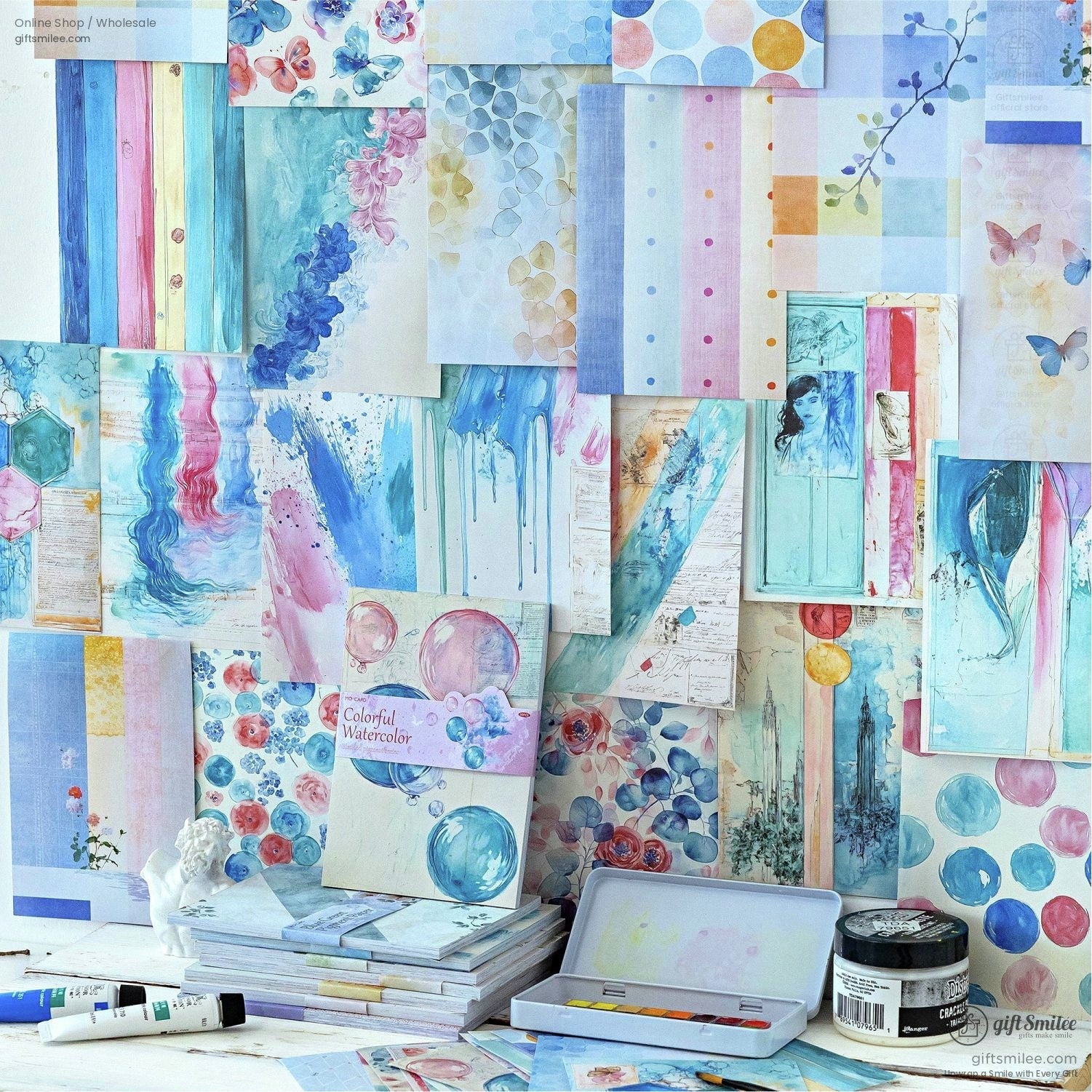 A colorful display of watercolor-themed scrapbook papers with floral and abstract designs