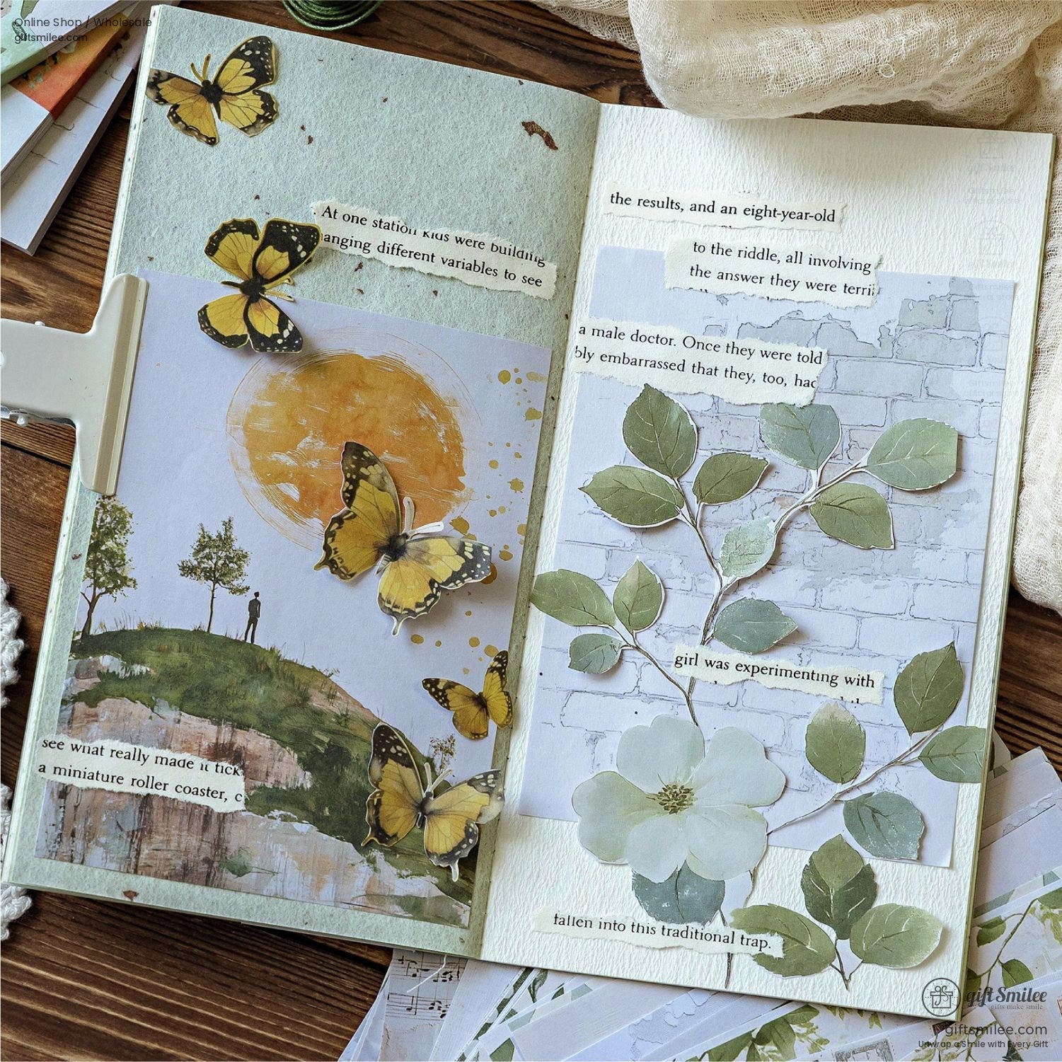 Open art journal showcasing butterfly and floral designs on textured paper backgrounds