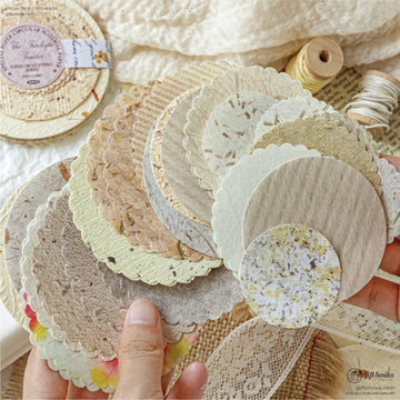 A close-up of scalloped decorative paper circles in soft earthy tones for crafting