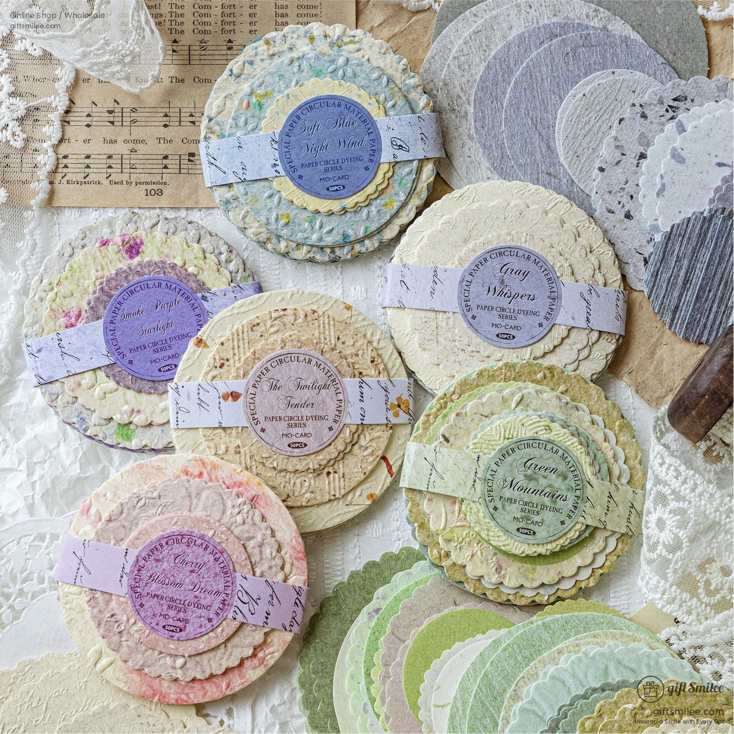 Various sets of circular vintage paper embellishments arranged beautifully with lace and vintage notes in the background