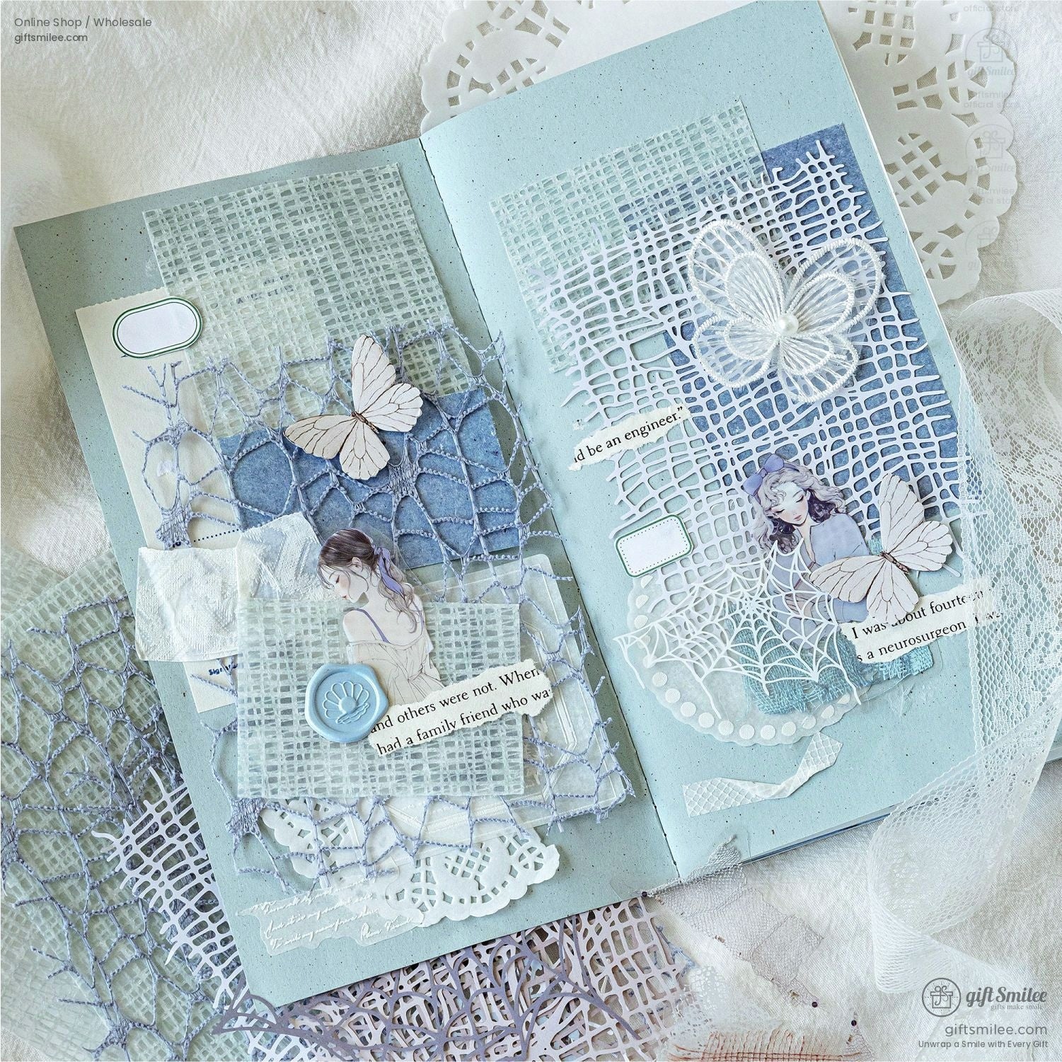 Open junk journal with blue and white mesh, lace, and butterfly embellishments