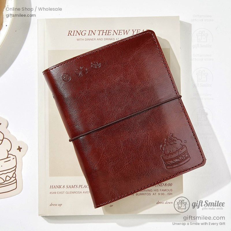 Red leather journal with a cake embossing on a book background