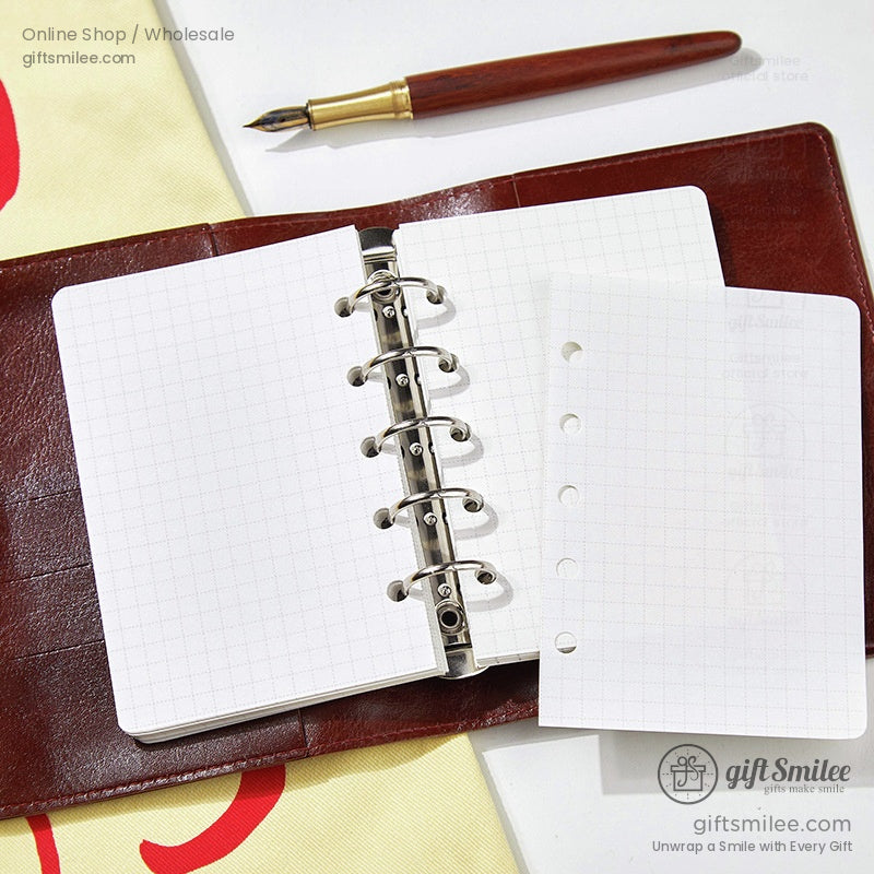 Open refillable leather journal with grid paper and a metal binder