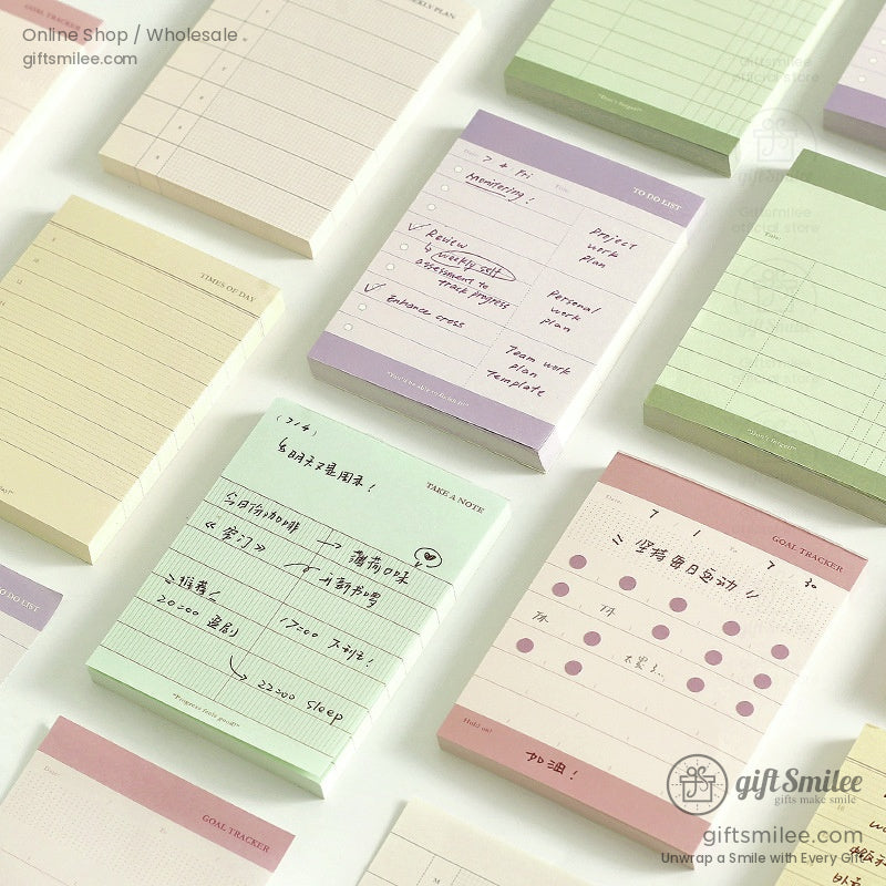 A set of minimalist to-do list and memo pads in soft pastel shades arranged flat