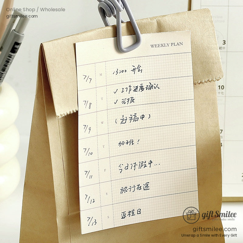 Weekly planner memo pad clipped to a bag with handwritten entries