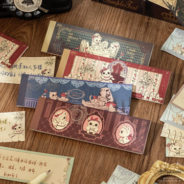 A collection of vintage cat-themed memo pads with intricate designs and floral accents on a wooden desk