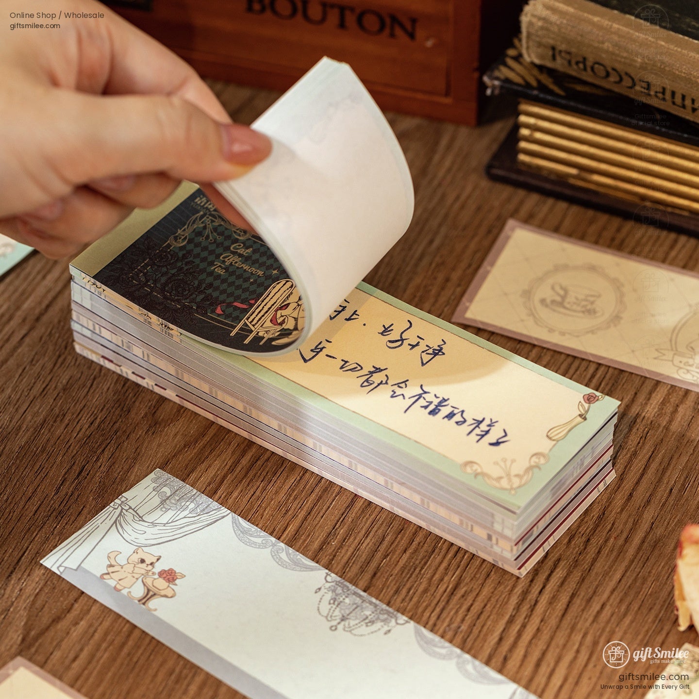 Hand flipping through a stack of aesthetic memo pads with cat illustrations and delicate patterns