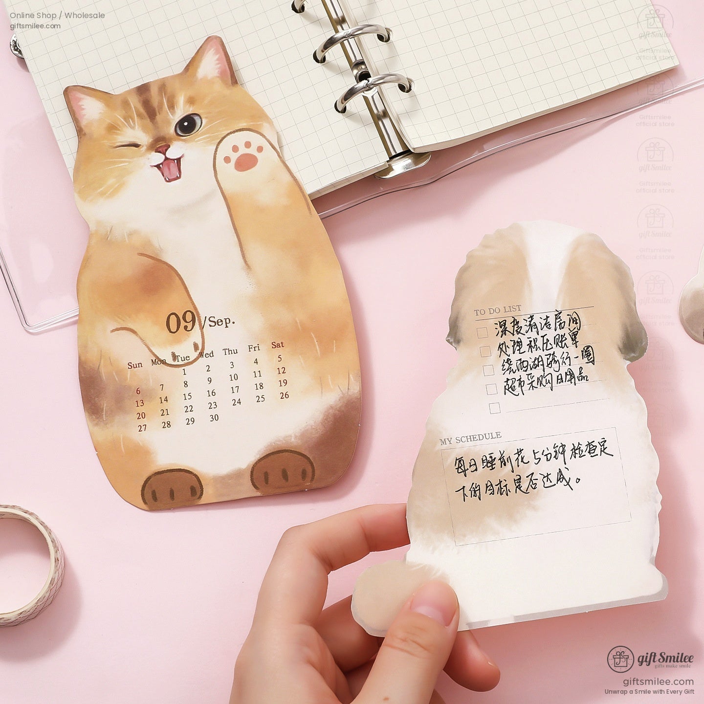 Close-up of a 2026 calendar page with a playful cat and dog illustration