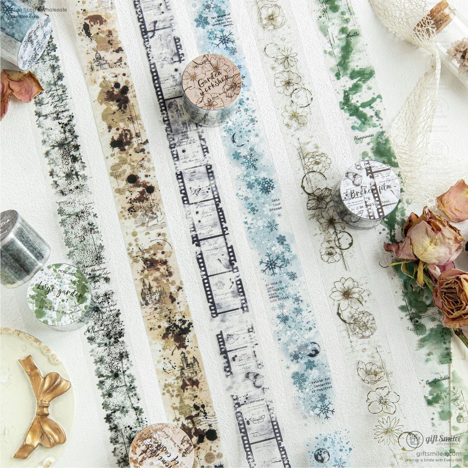 A close-up of vintage-inspired washi tape with floral, film strip, and snowflake designs arranged artistically on a white surface.
