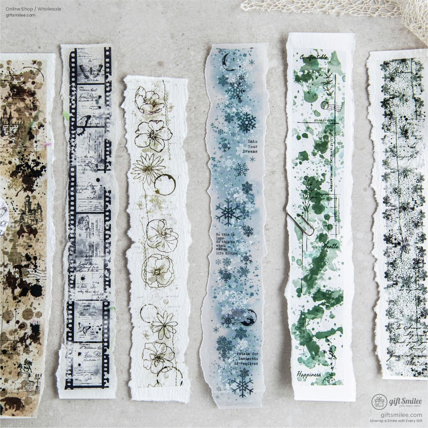 A variety of vintage washi tape designs, including snowflakes, florals, and film strips, displayed on torn paper strips.