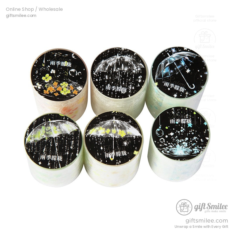 Top view of washi tape rolls showcasing intricate umbrella and rain designs in holographic detail