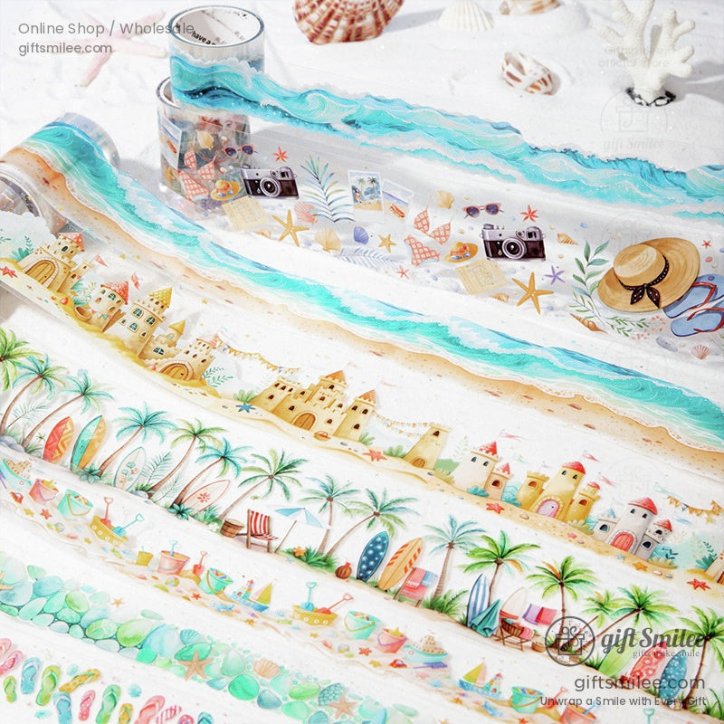 Close-up of washi tape with designs of sandcastles, ocean waves, and tropical patterns spread on a sandy background.