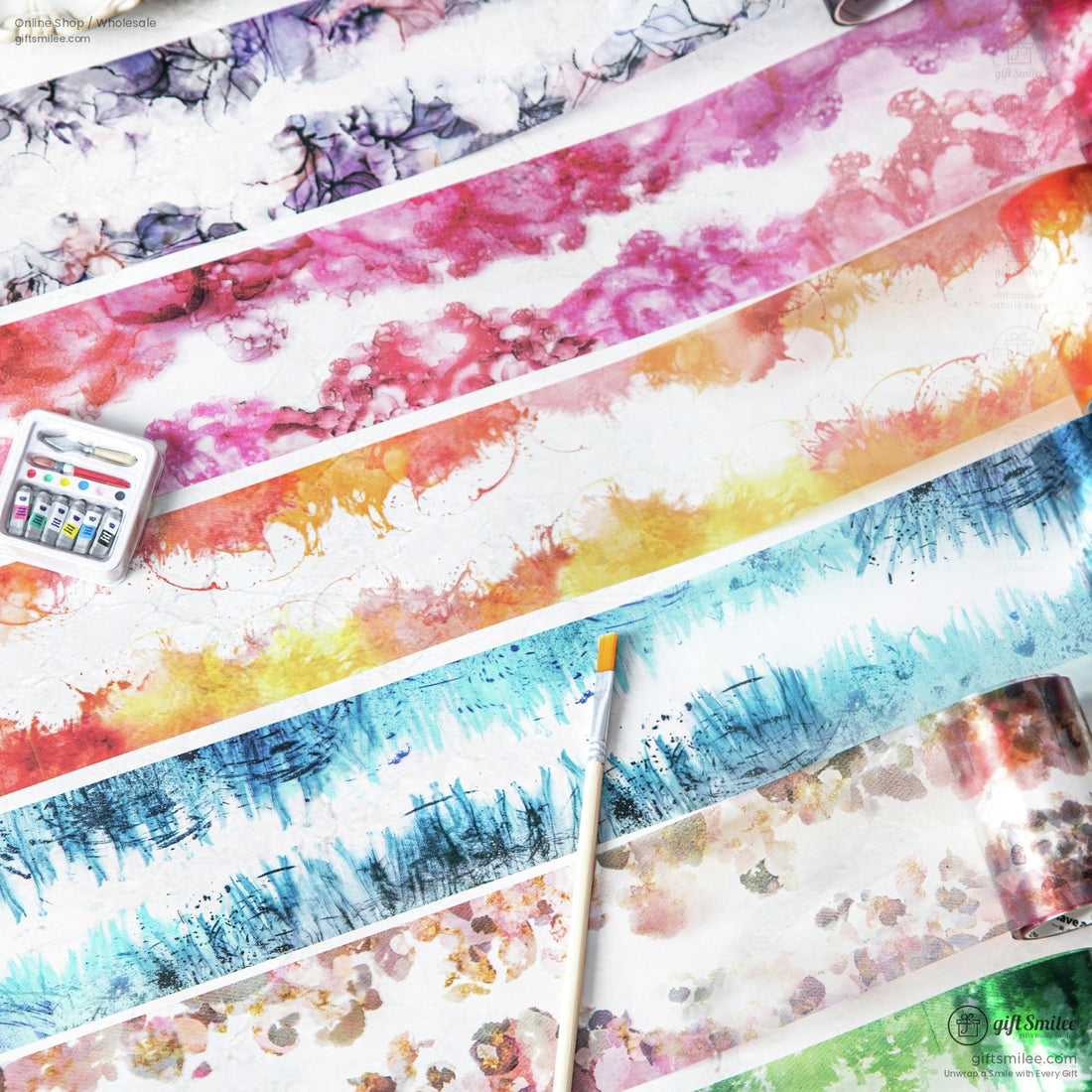Close-up of watercolor washi tape rolls in vibrant pink, blue, and floral patterns for arts and crafts.