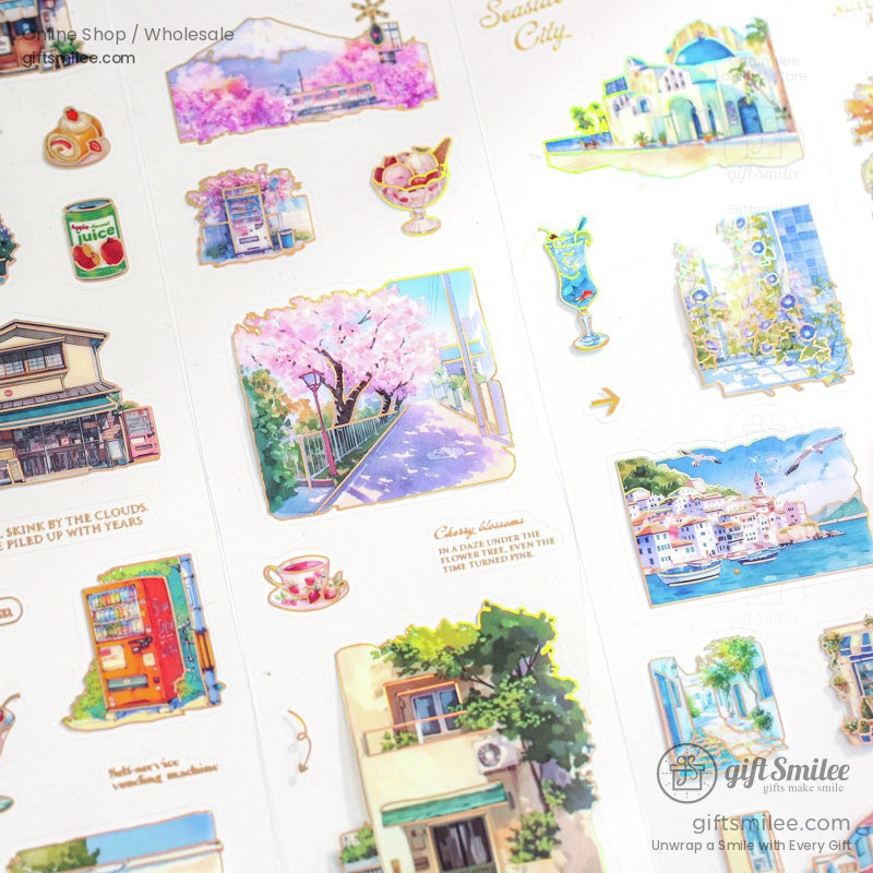 Close-up of washi tape stickers with cherry blossoms, vintage buildings, and coastal scenery on a white background