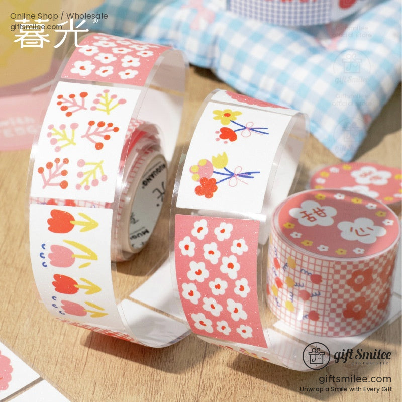 Close-up of pink floral washi tape rolls featuring tulip and cherry blossom designs