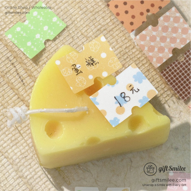A creative arrangement of washi tape strips with a yellow cheese-shaped candle, highlighting crafting possibilities