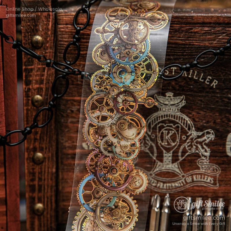 A roll of transparent washi tape with golden mechanical gears against a rustic wooden background
