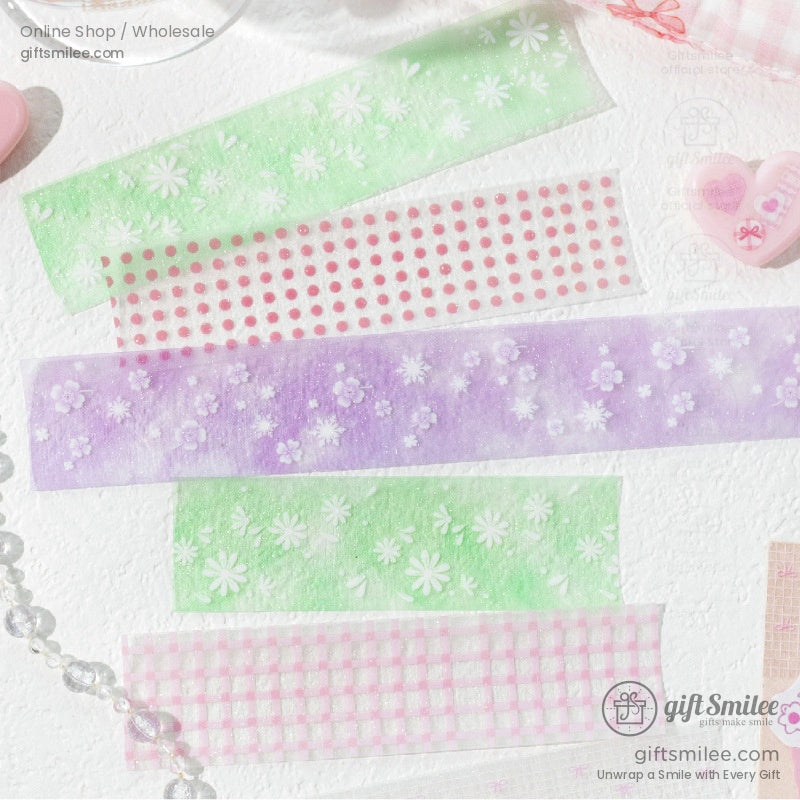 A set of pastel green, pink, and purple floral-patterned washi tapes on a white surface