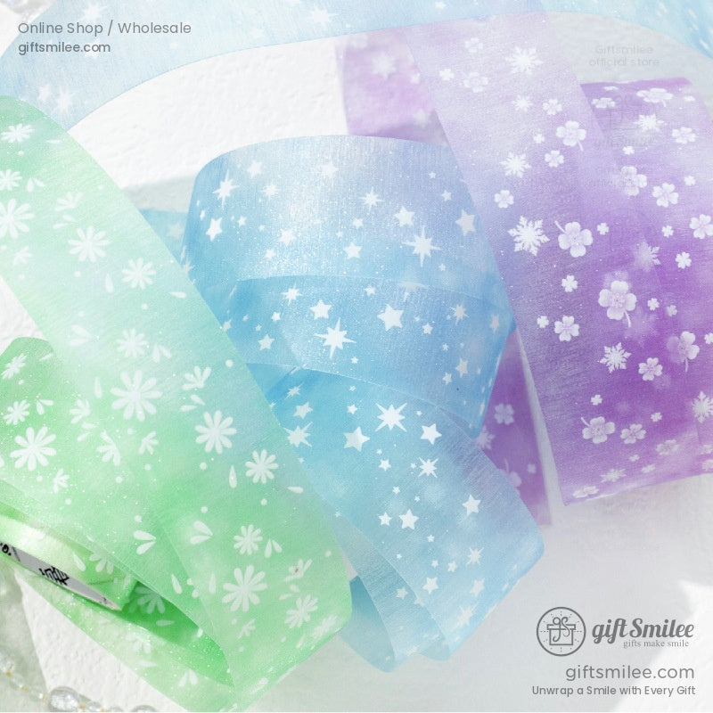 A set of pastel green, pink, and purple floral-patterned washi tapes on a white surface