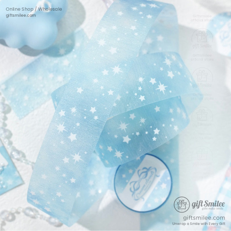 A single roll of light blue washi tape with a starry design, surrounded by soft decor