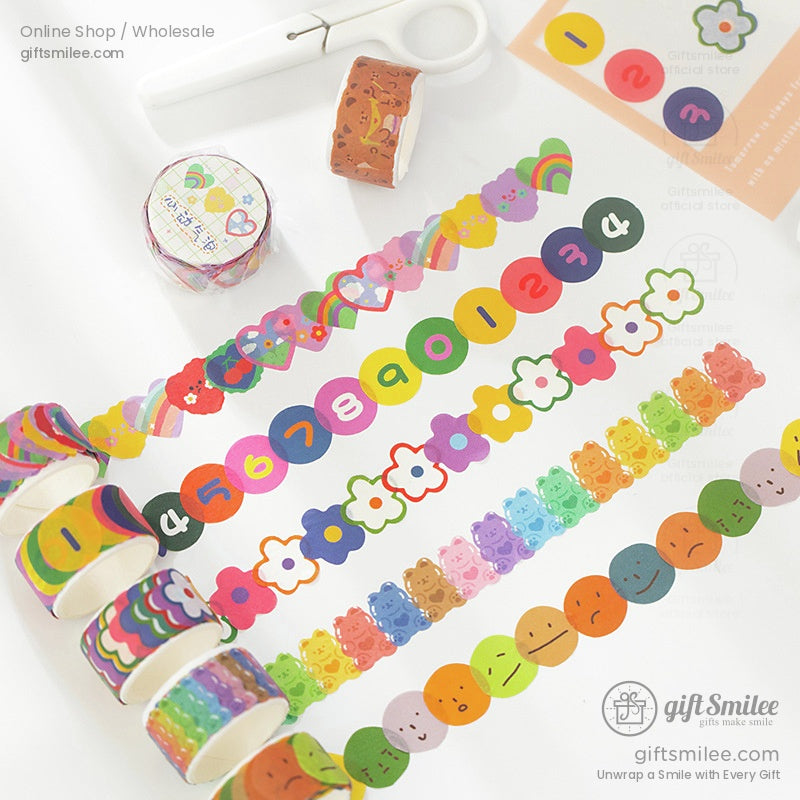 A set of colorful washi tapes with rainbow, bear, and floral patterns displayed on a desk