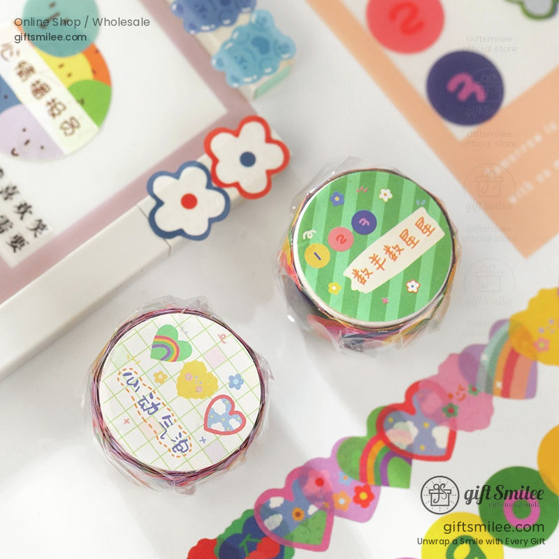 A set of colorful washi tapes with rainbow, bear, and floral patterns displayed on a desk