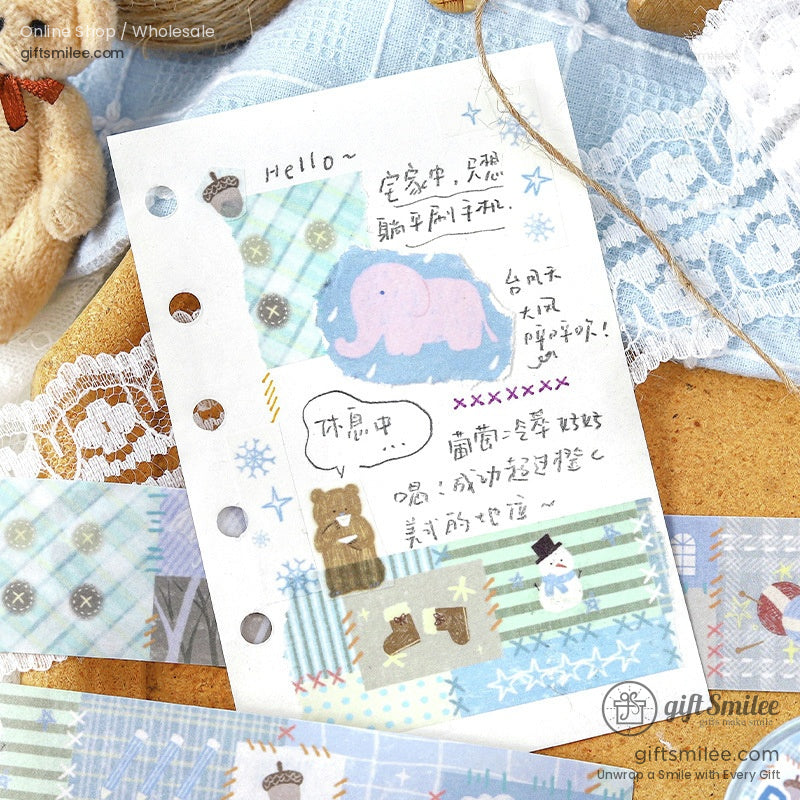 Close-up of decorative masking tape featuring pastel elephants, bears, and snowflakes on a journal page