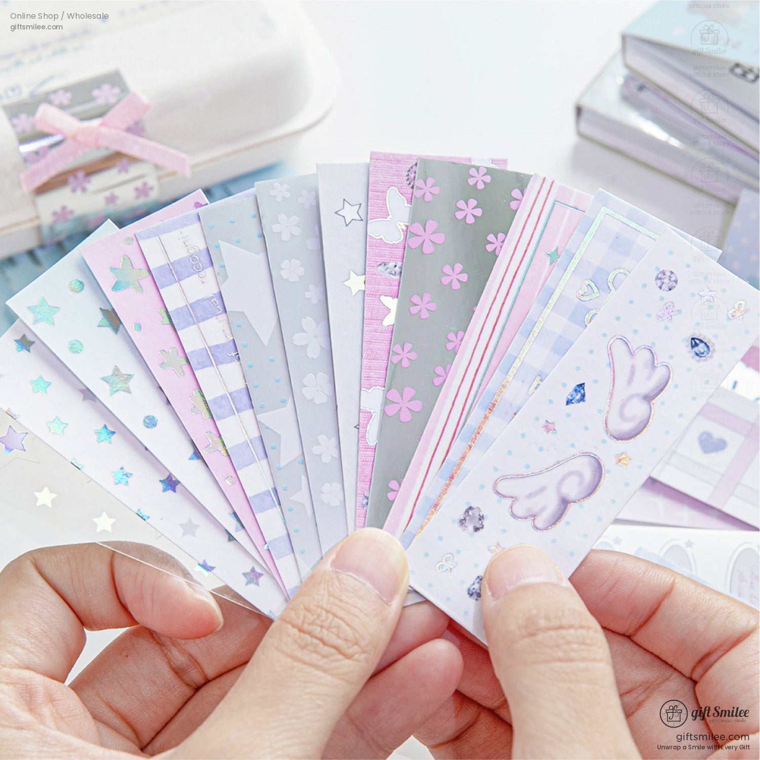 A hand fanning out pastel holographic stickers with star and floral designs
