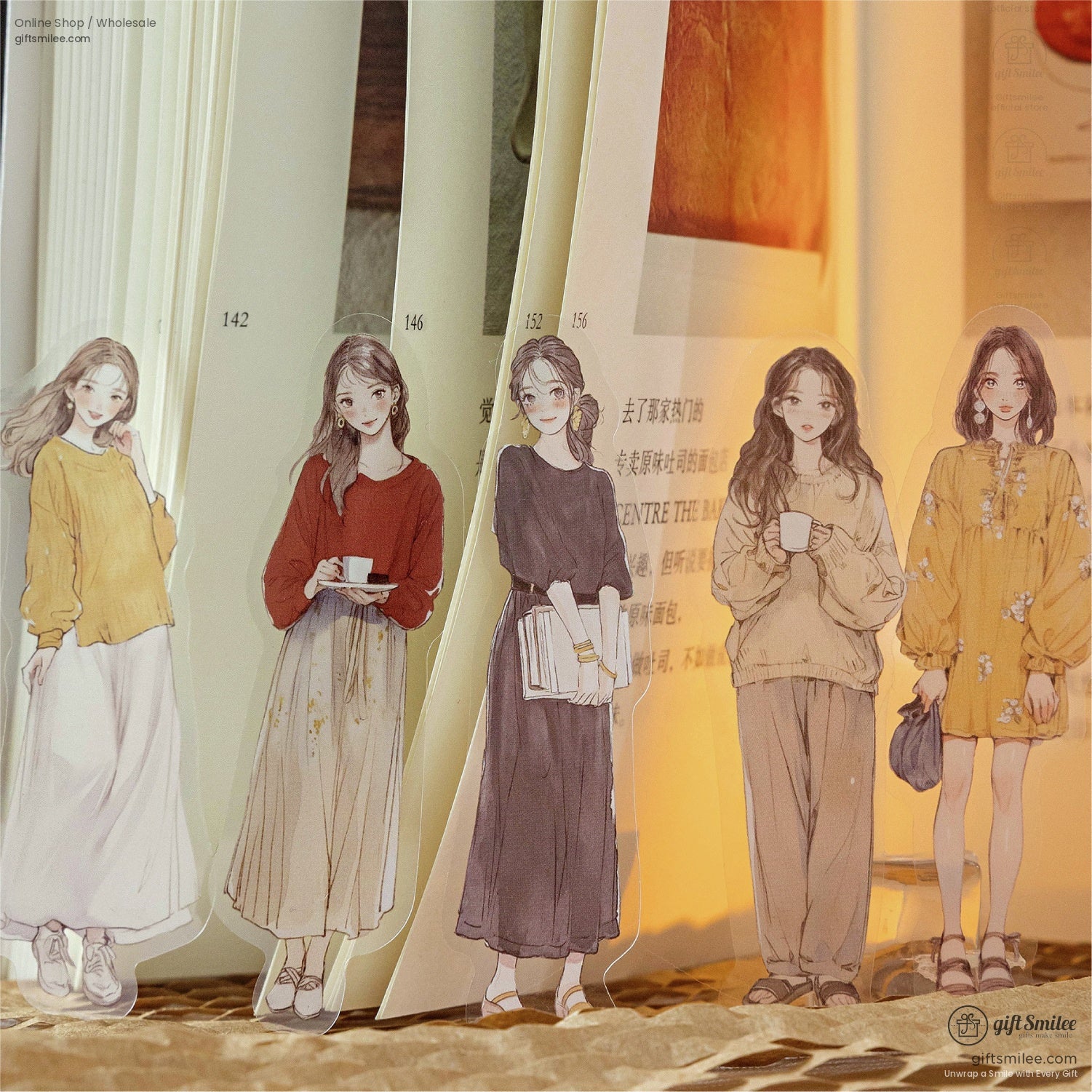 Girls in vintage outfits as stickers, displayed on a book with warm lighting.