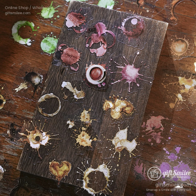 Artistic coffee stain and splash-shaped stickers scattered on a wooden surface.