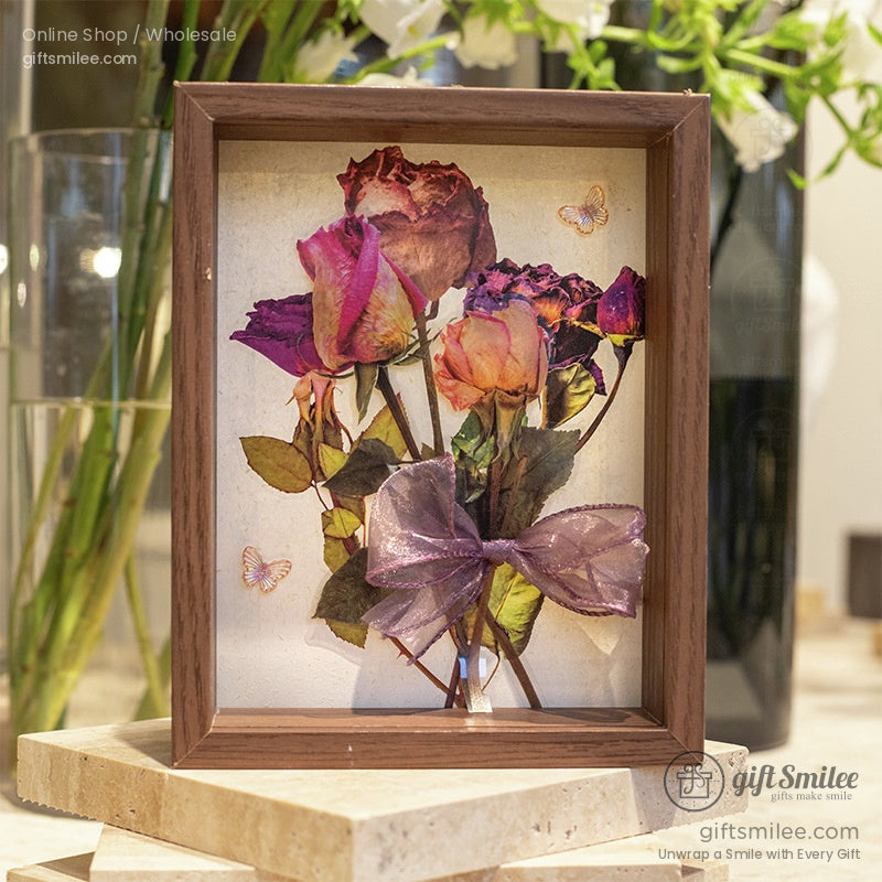 Decorative framed art featuring pressed rose stickers with a purple ribbon bow