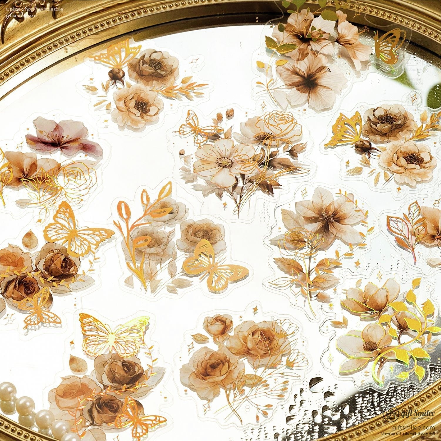 Assorted vintage floral stickers arranged on a reflective surface, highlighting roses, butterflies, and decorative elements.