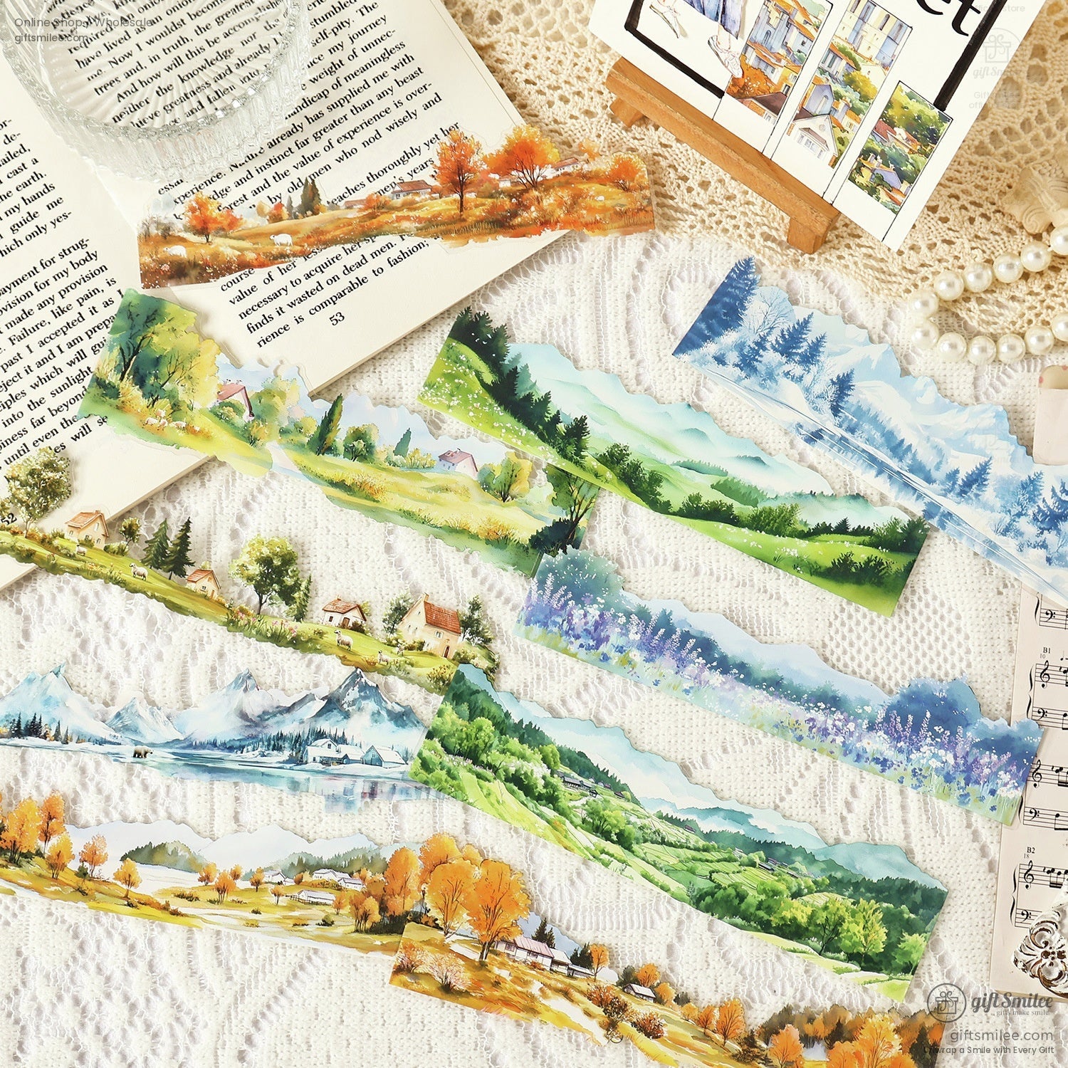 A display of colorful washi sticker strips with mountain views, green meadows, and rustic cottages