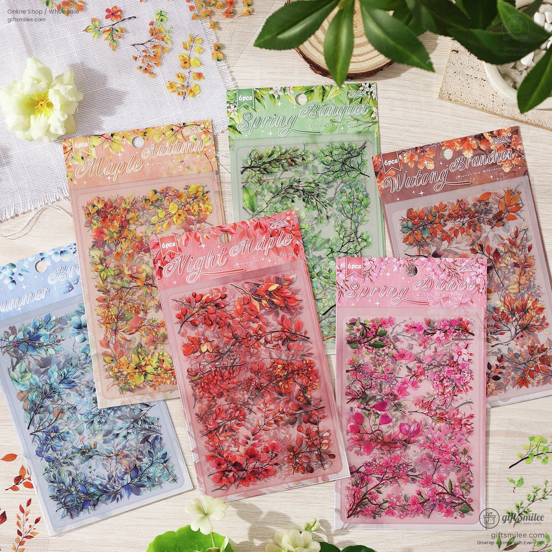 A set of six seasonal floral sticker packs displayed on a wooden surface with delicate flowers and leaves surrounding them