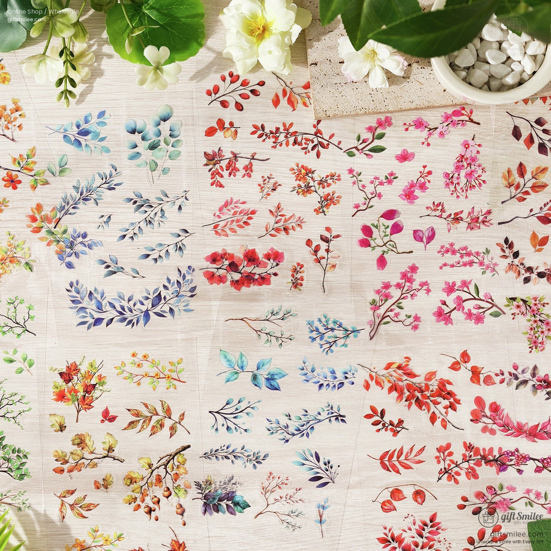 A set of six seasonal floral sticker packs displayed on a wooden surface with delicate flowers and leaves surrounding them