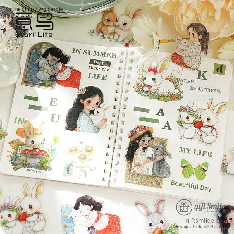 Open journal decorated with stickers of girls, bunnies, and flowers in a whimsical theme