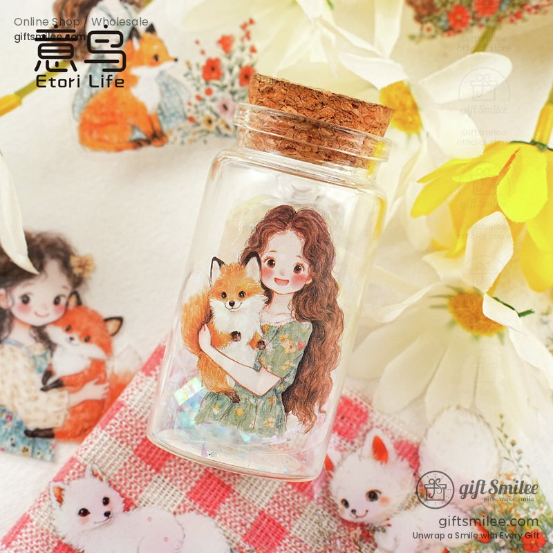 Glass jar with a sticker of a girl holding a fox surrounded by floral decorations